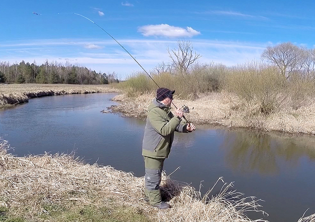 Спиннинг делает заброс по реке Спиннинг делает заброс по реке