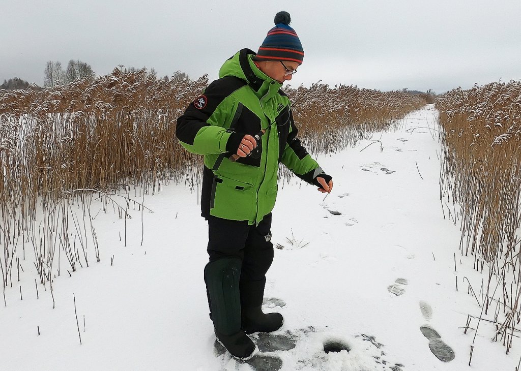 Балансирщик опускает приманку в лунку Балансирщик опускает приманку в лунку