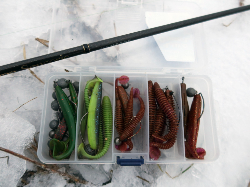 Коробка с джиговыми приманками на снегу