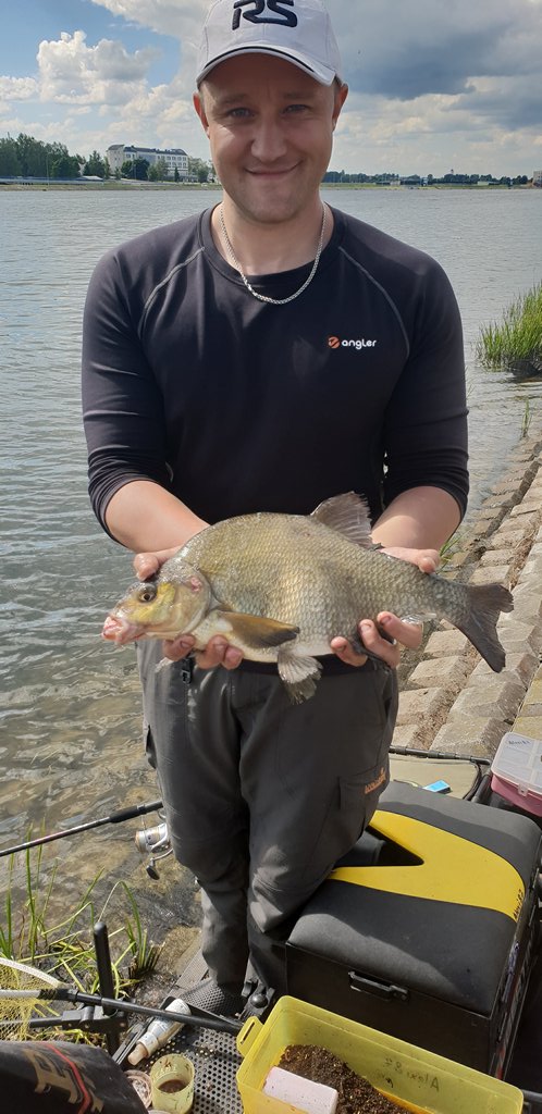 Рыбак держит леща пойманного на фидер