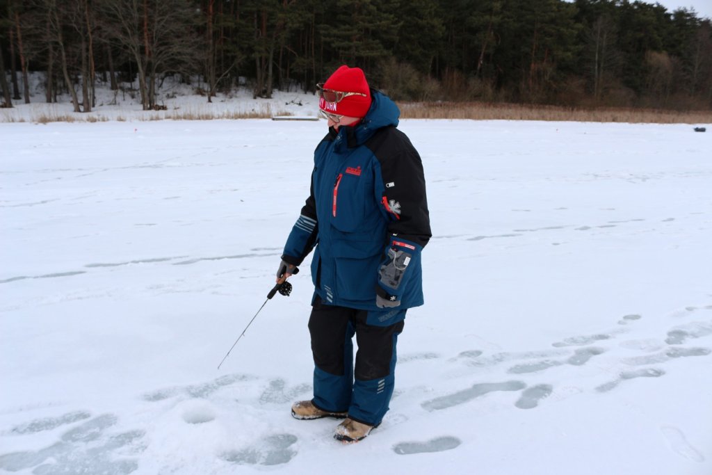 Рыбачка ловит стоя на льду