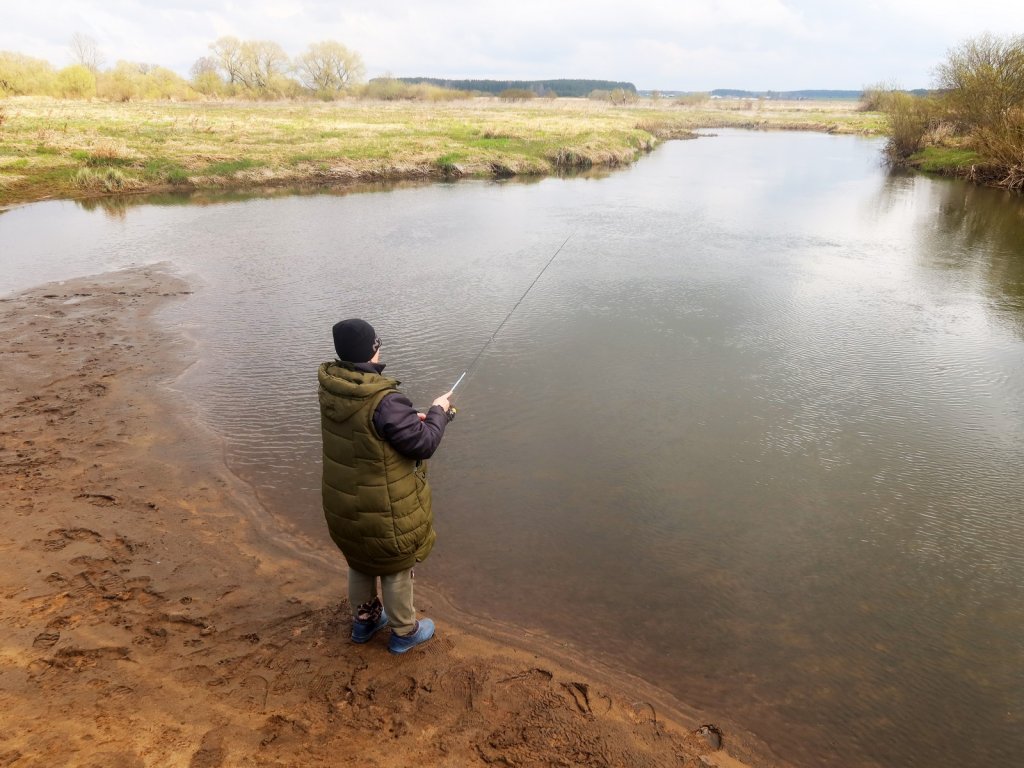 Рыбачка ловит спиннингом на реке