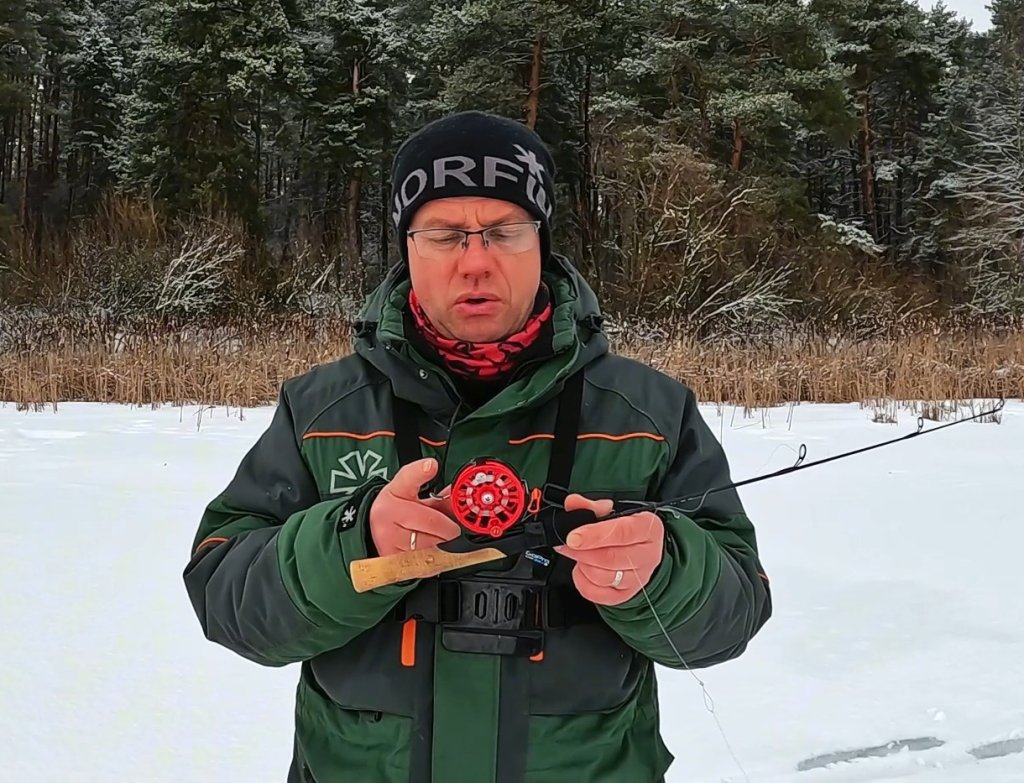 Рыболов показывает зимнюю удочку