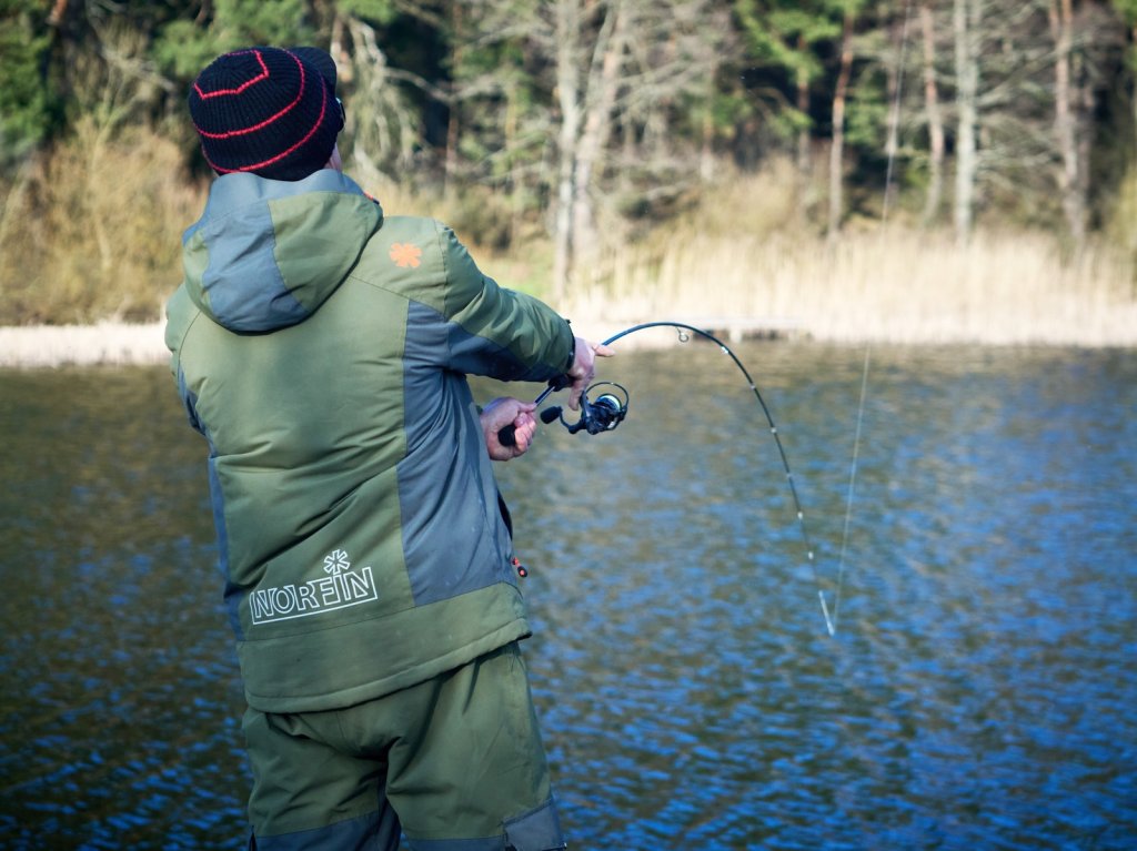 Спиннингист делает заброс Спиннингист делает заброс