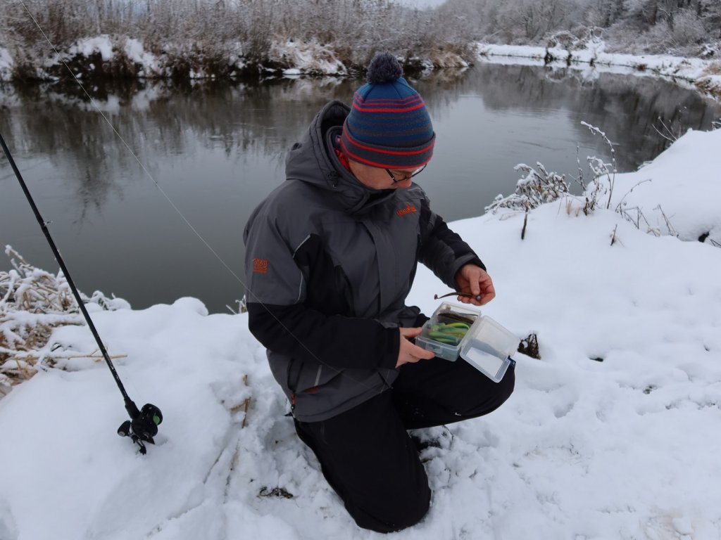 Спиннингист выбирает мягкую приманку в коробке