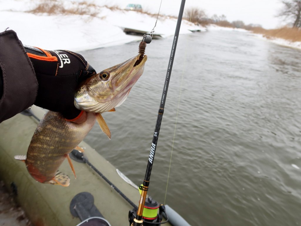 Щука и спиннинг на фоне зимней реки