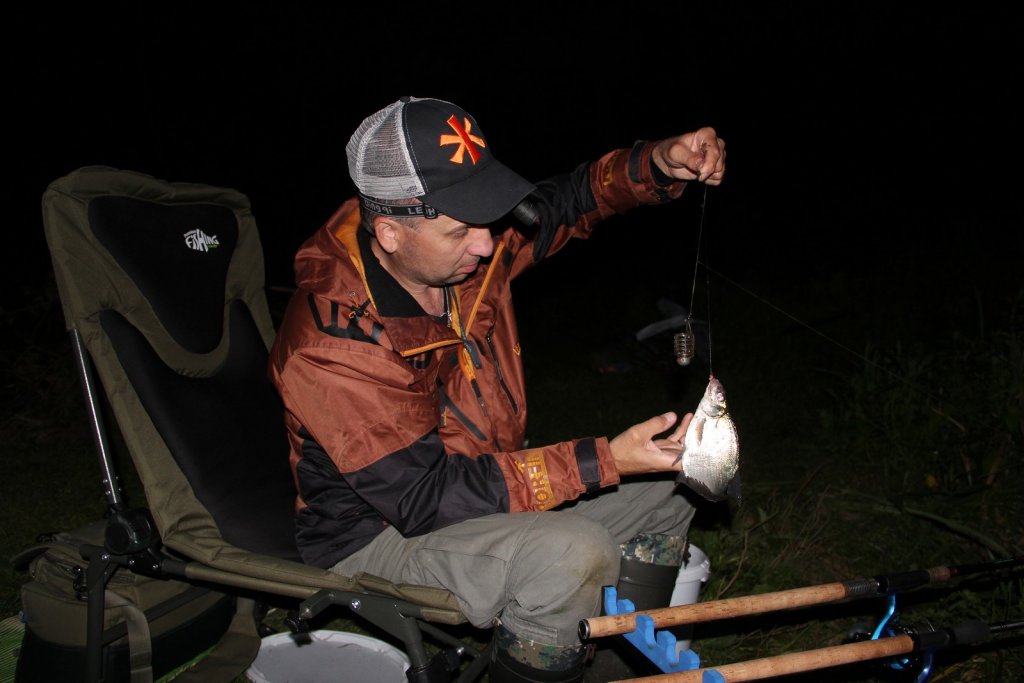 Рыболов ловит фидером ночью