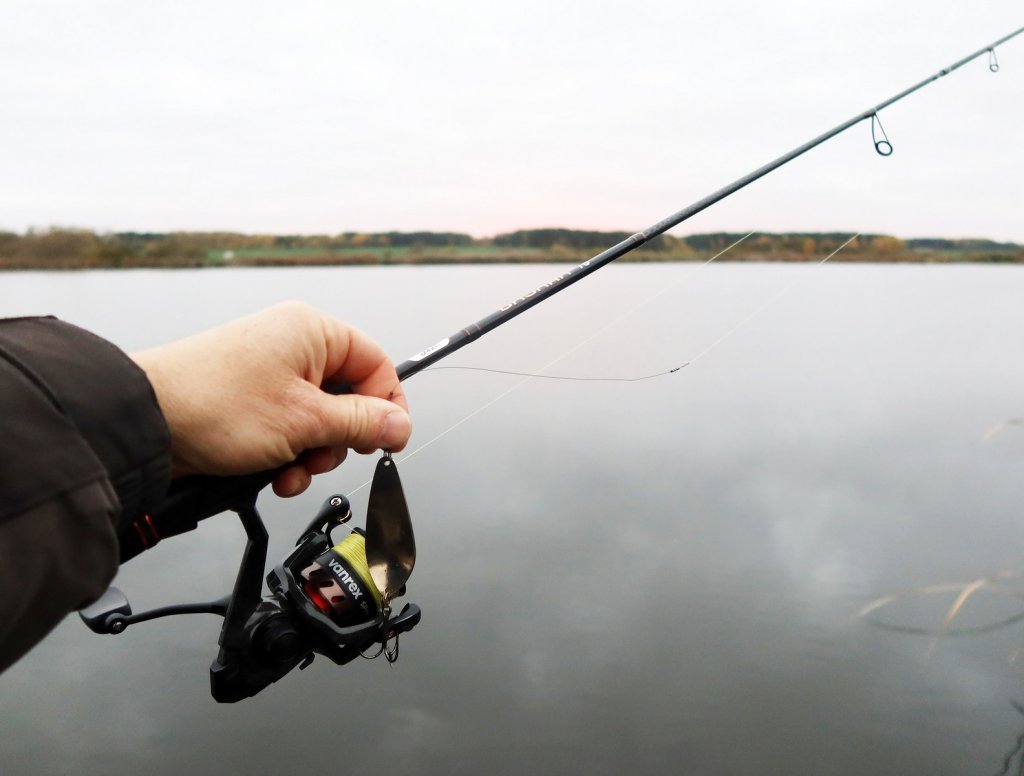 Спиннинговая снасть и колебалка на фоне водоёма