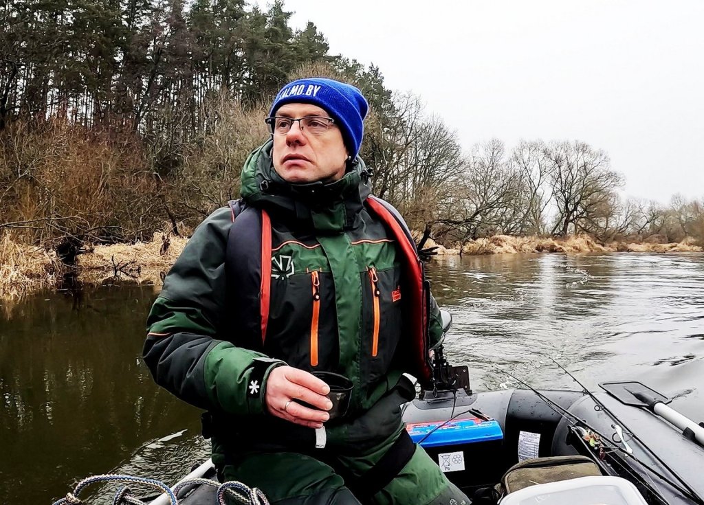 Рыболов плывёт по реке на электромоторе Рыболов плывёт по реке на электромоторе